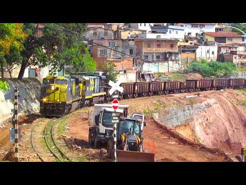 A imagem capturada revela um cenário dinâmico e intrínseco à realidade de muitas cidades mineiras: a convivência diária entre o tráfego ferroviário, o d...