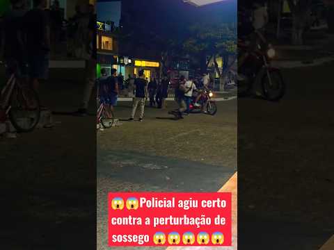 Uma cena registrada em uma localidade urbana noturna mostra a intervenção da Polícia Militar para conter uma situação de **perturbação de sossego**. O i...